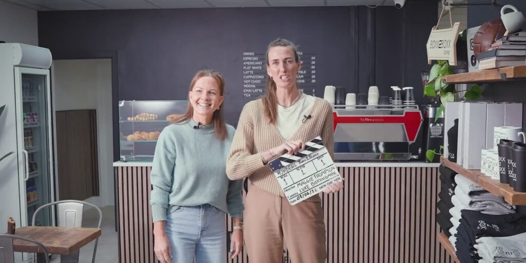 A film crew with a clapperboard on a shoot in a cafe
